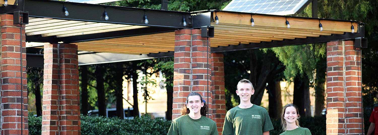 NC State Stewards (left to right) Benjamin Helms, Elias Zauscher and Alie Akins at SolarSpace, a new outdoor study space powered by renewable energy.