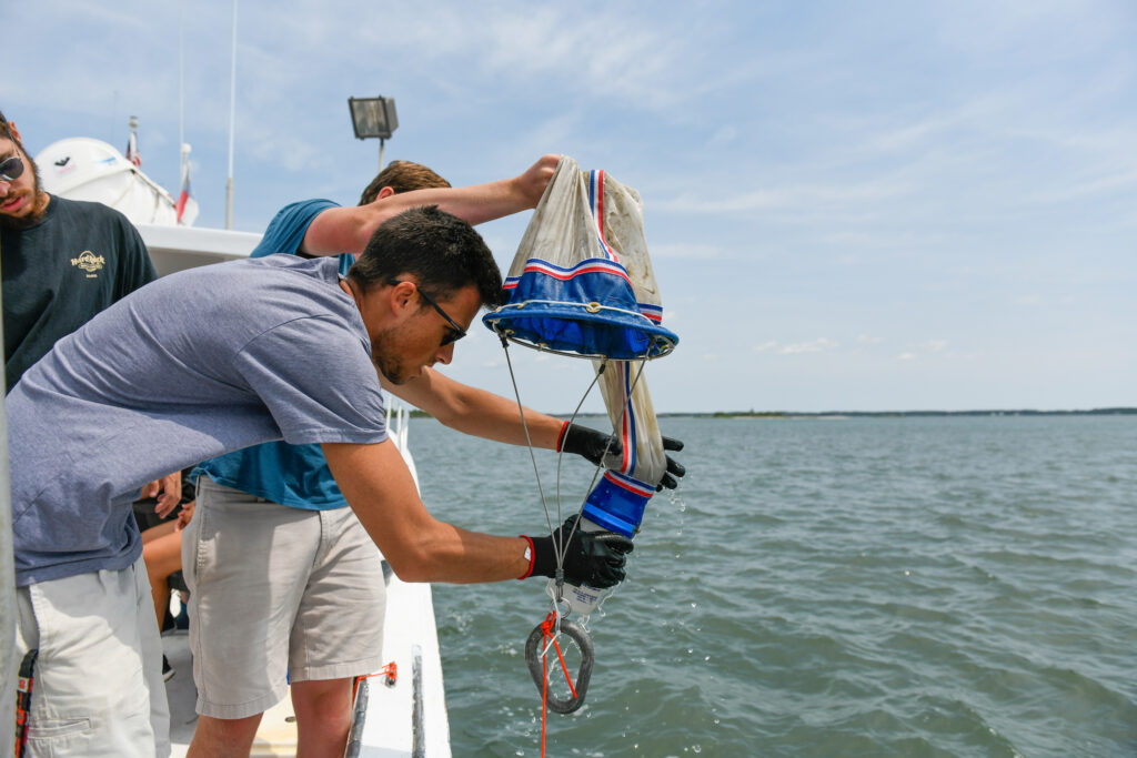 Undergraduate students work on a university boat taking water samples at CMAST