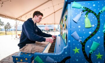 NC State student Andrew Farkas plays the piano on Centennial Campus