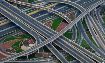 aerial view of a complex highway interchange featuring more than a dozen lanes of traffic going in half a dozen directions