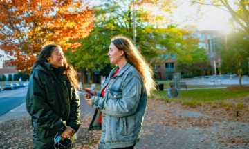 International students from France enjoy the fall weather on Centennial Campus while waiting for the Wolfline bus. Photo by Becky Kirkland.