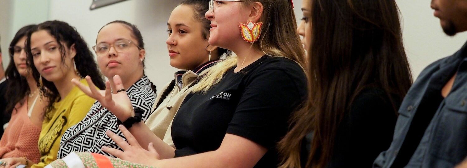 Native students sit side by side on a panel.