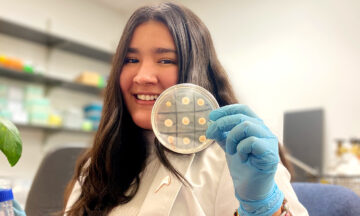Young woman holding up a lab sample
