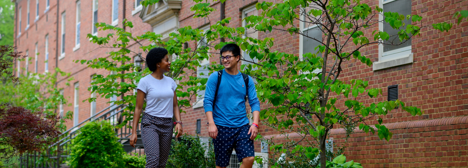 Undergraduate students gather by flowers near Tuck in between residence halls on main campus. Photo by Marc Hall
