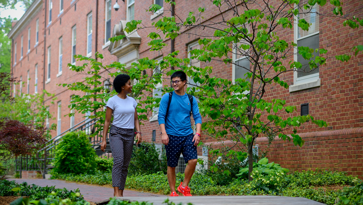 Undergraduate students gather by flowers near Tuck in between residence halls on main campus. Photo by Marc Hall