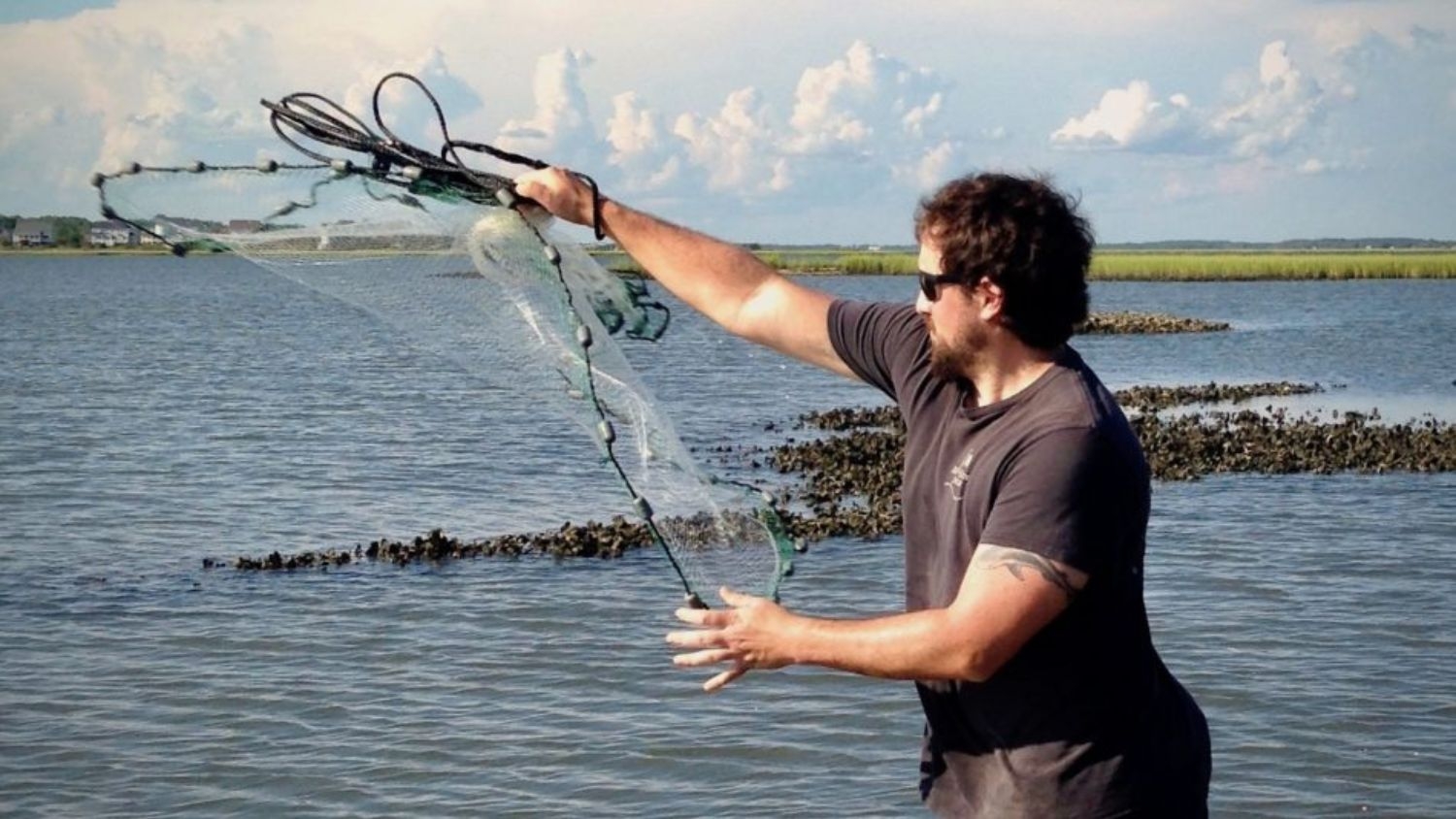 a man casting a net into the water