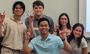 Team members Jason Oliva Milla, Eric Daniel, Lawrence Navarro, Allison Keever and Julia David celebrate after presenting their capstone project, Site Evaluation and Design for Renewable Energy and Electric Vehicle Charging.