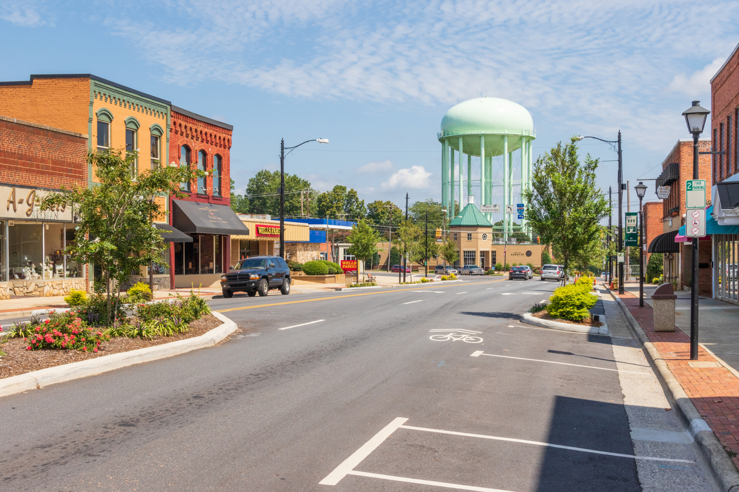 The main street of Conover, NC, a small southern town. Small shops line the street on each side, and light green water tower is visible in the distance.