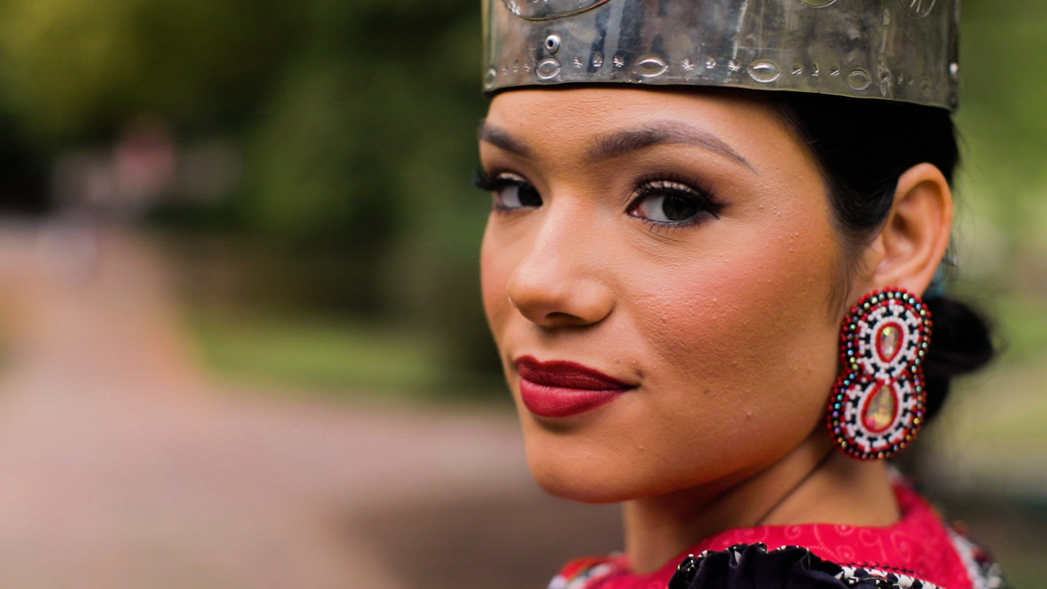 Ashtyn Thomas, Miss Lumbee 2023, looks over her shoulder at the camera while wearing the Miss Lumbee crown.