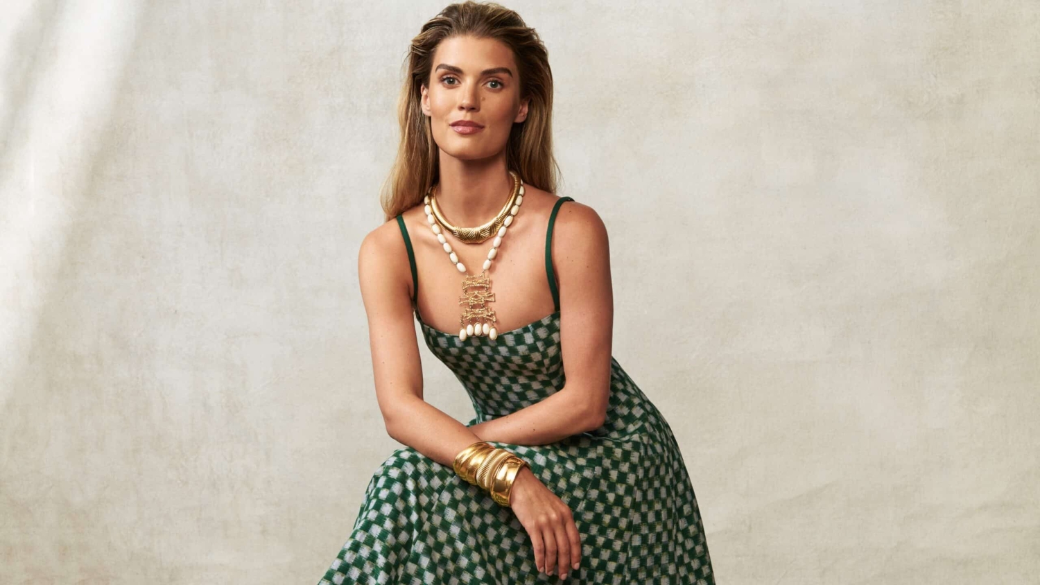 Agee Leinberry models a green and white checkered dress accessorized with gold jewelry.