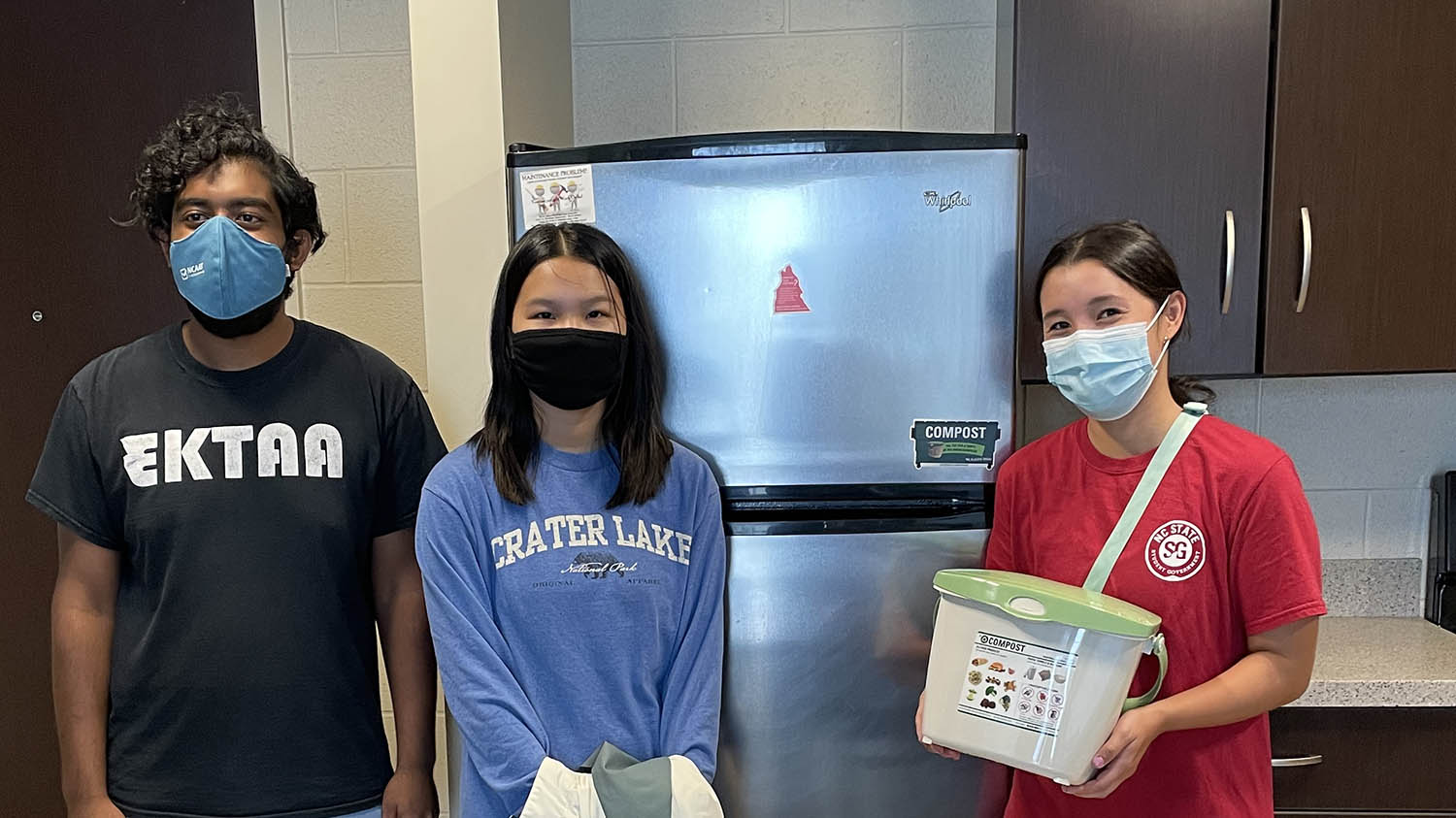 Students pose with compost pail.