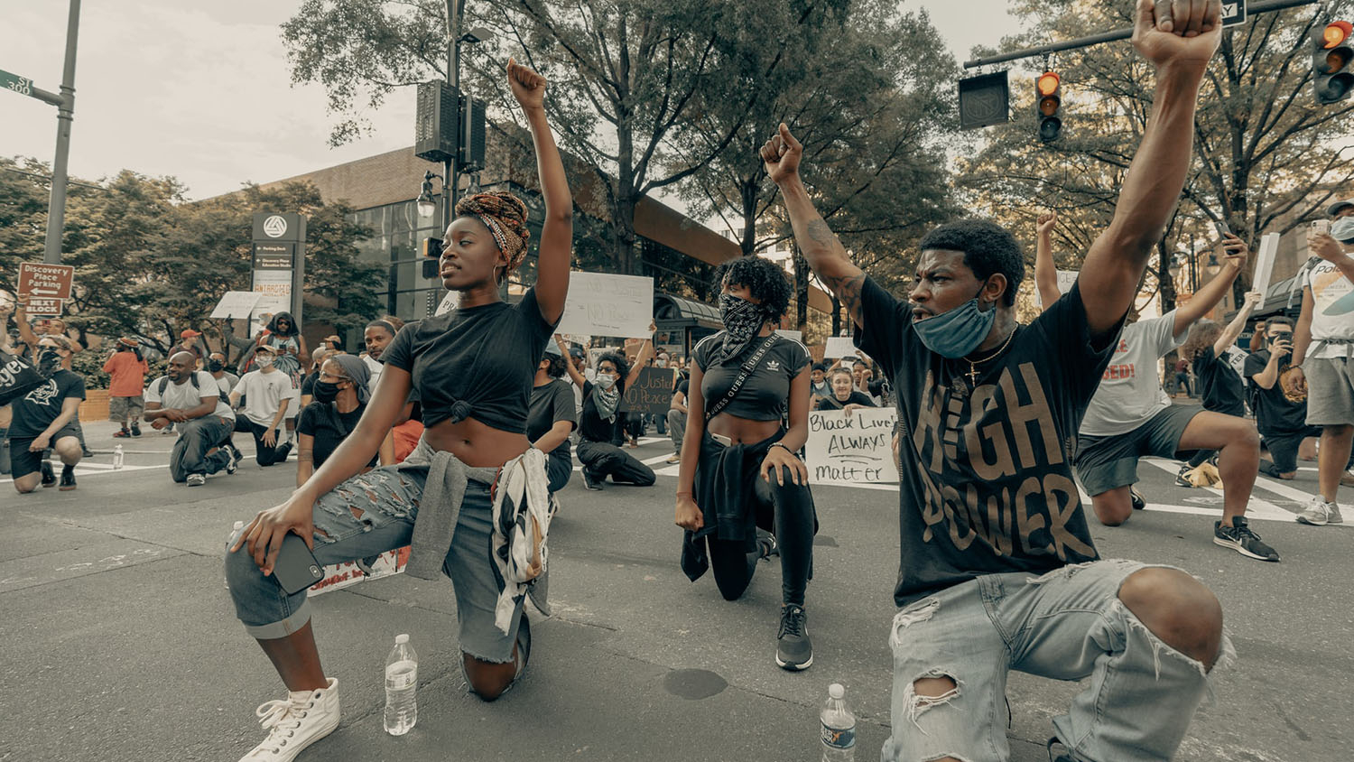 several Black young people kneel as part of a Black Lives Matter protest