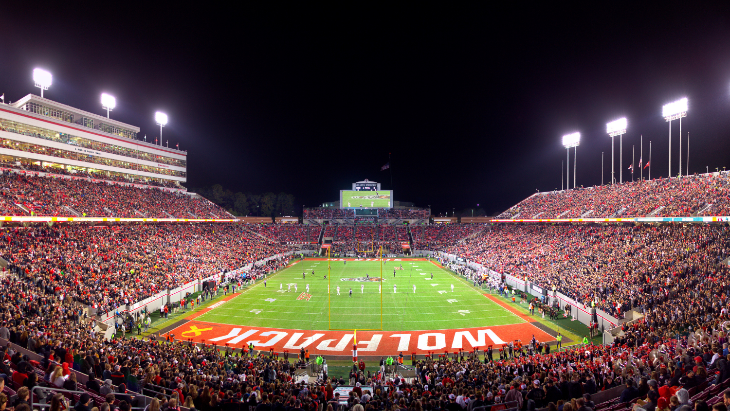 Carter Finley Stadium filled with spectators at night.