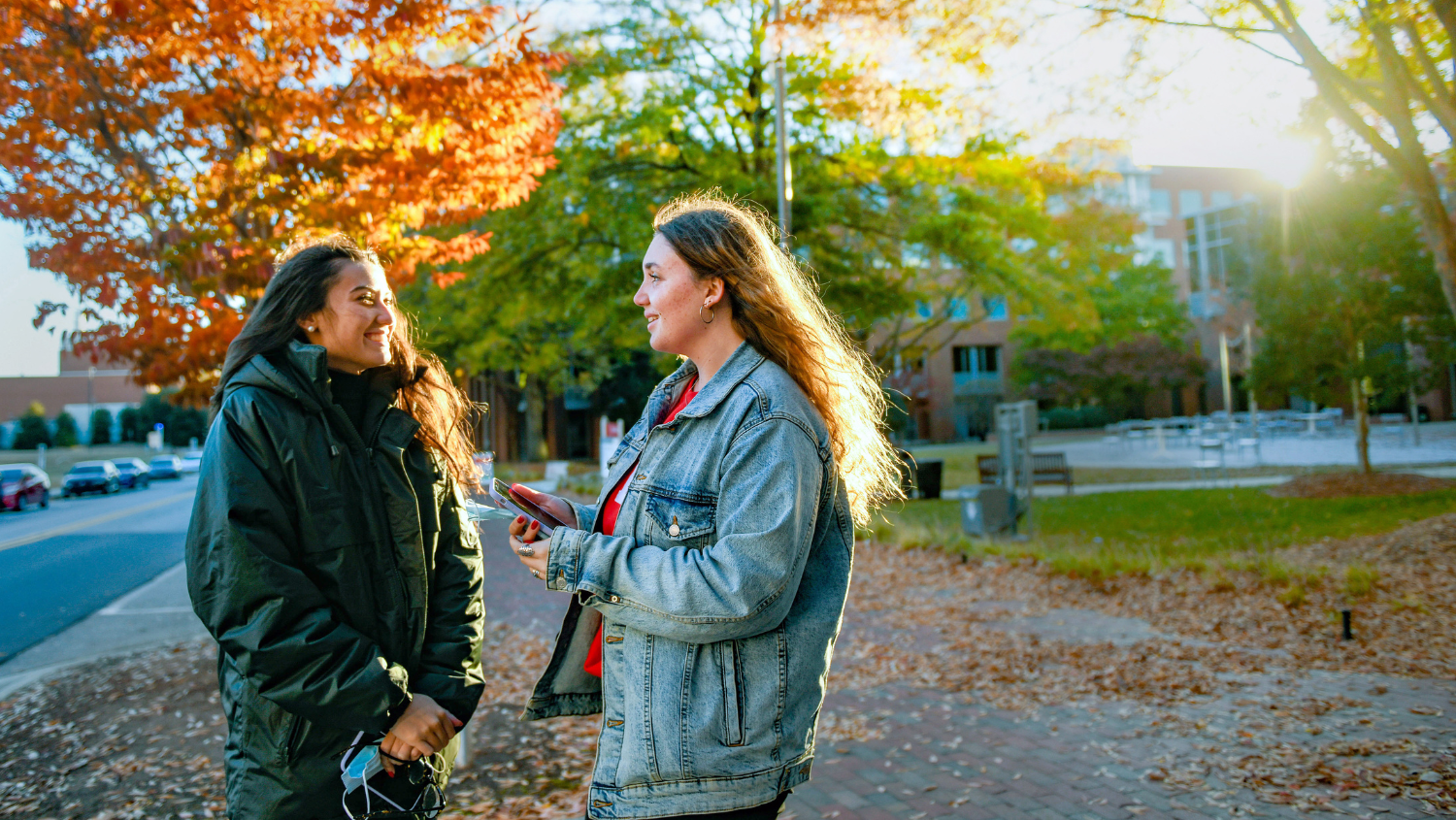 International students from France enjoy the fall weather on Centennial Campus while waiting for the Wolfline bus. Photo by Becky Kirkland.
