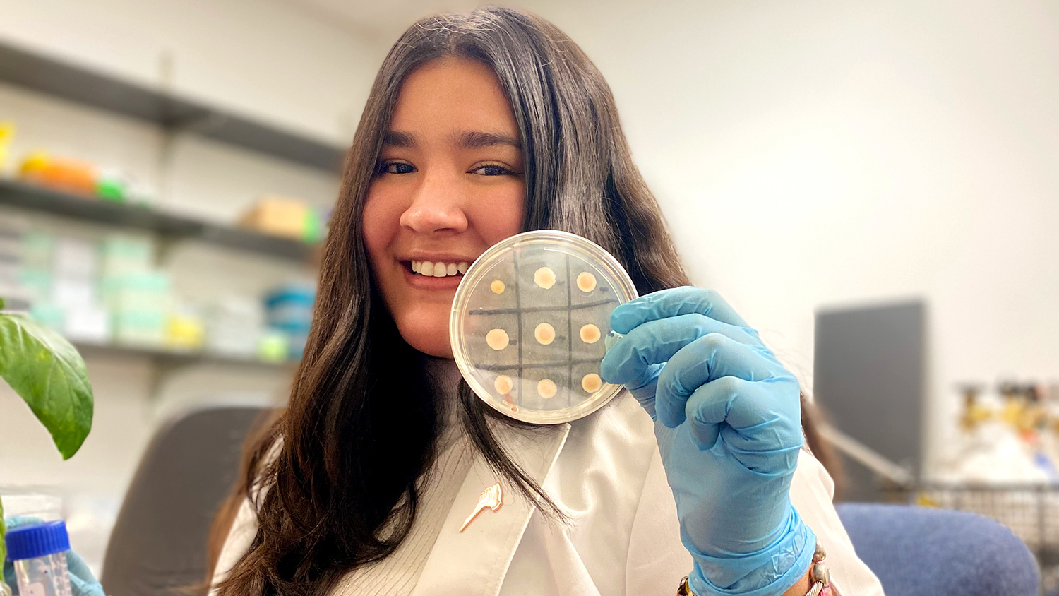 Young woman holding up a lab sample