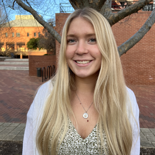 Headshot of Brynn Capuano in front of tree.