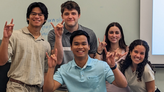 Team members Jason Oliva Milla, Eric Daniel, Lawrence Navarro, Allison Keever and Julia David celebrate after presenting their capstone project, Site Evaluation and Design for Renewable Energy and Electric Vehicle Charging.