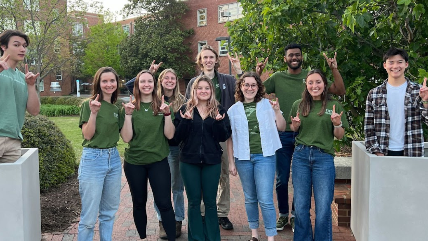 Sustainability Stewards posing at a Campus Green Haven, an outdoor green space designed to promote student wellness.