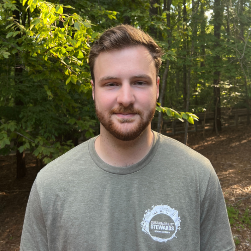 Headshot of Sustainability Stewards Griffin Smith wearing green tshirt outside in front of treeline