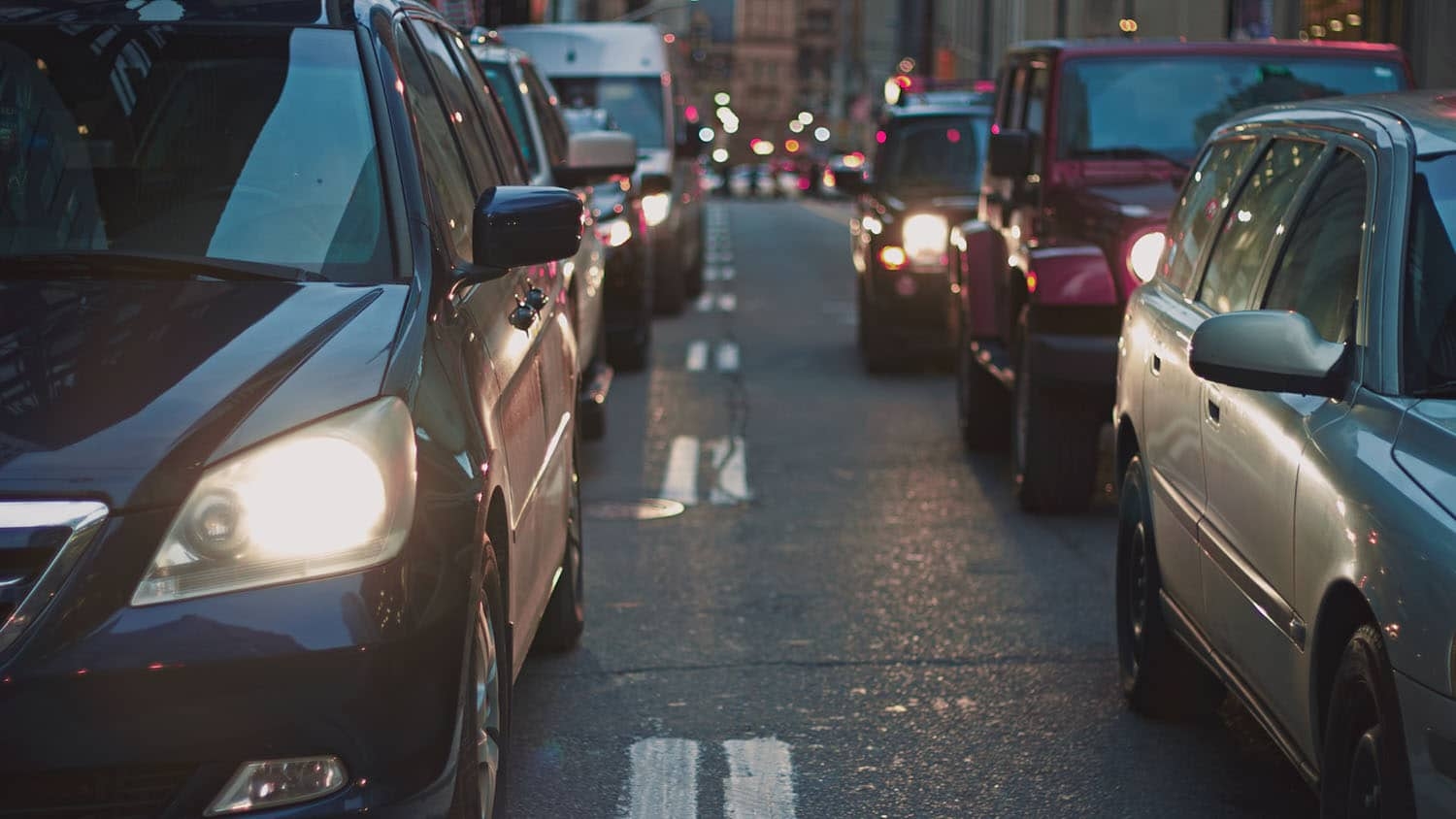 photo shows two rows of cars backed up as far as the eye can see.