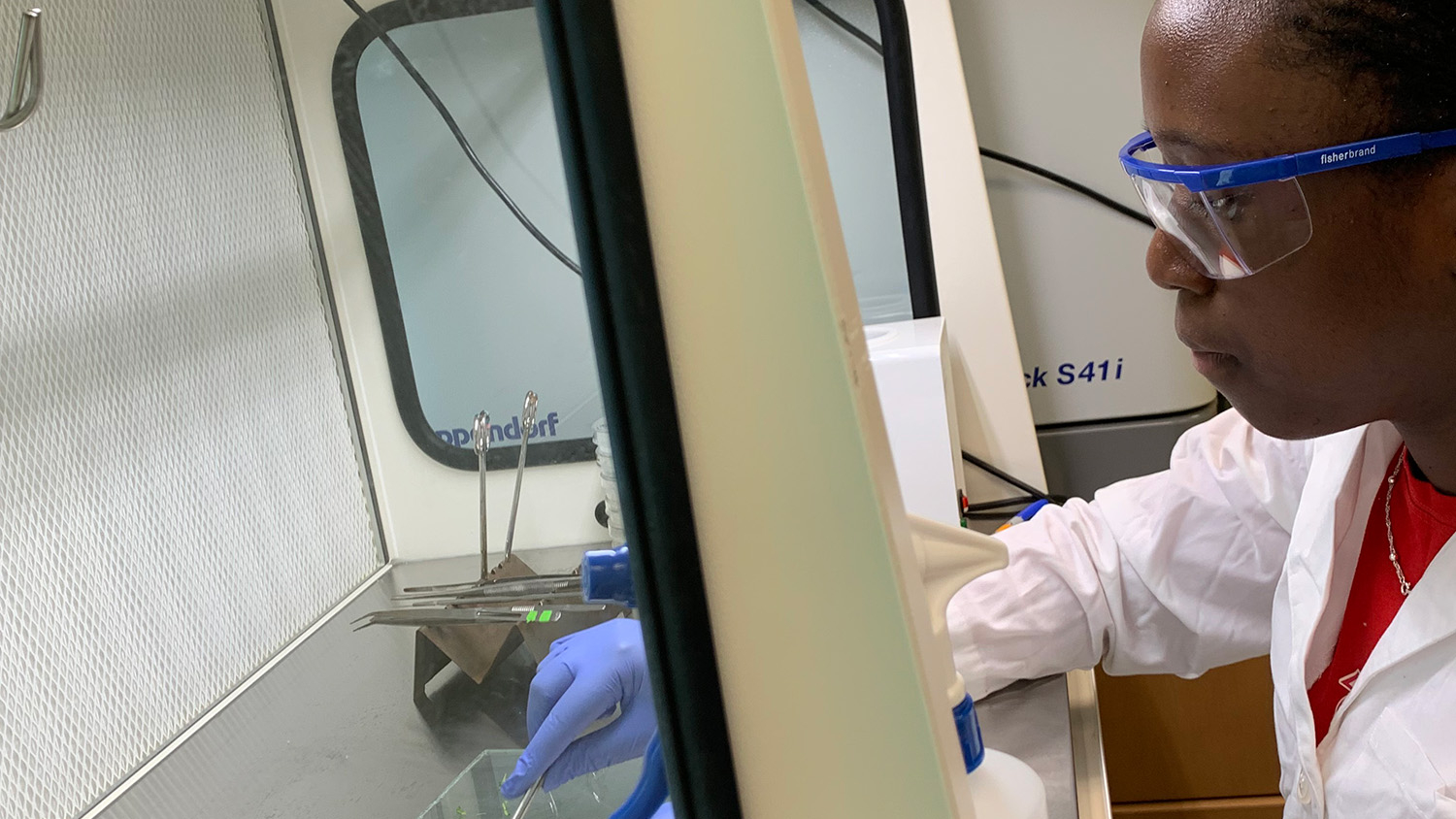 Young woman with protective glasses working in a lab