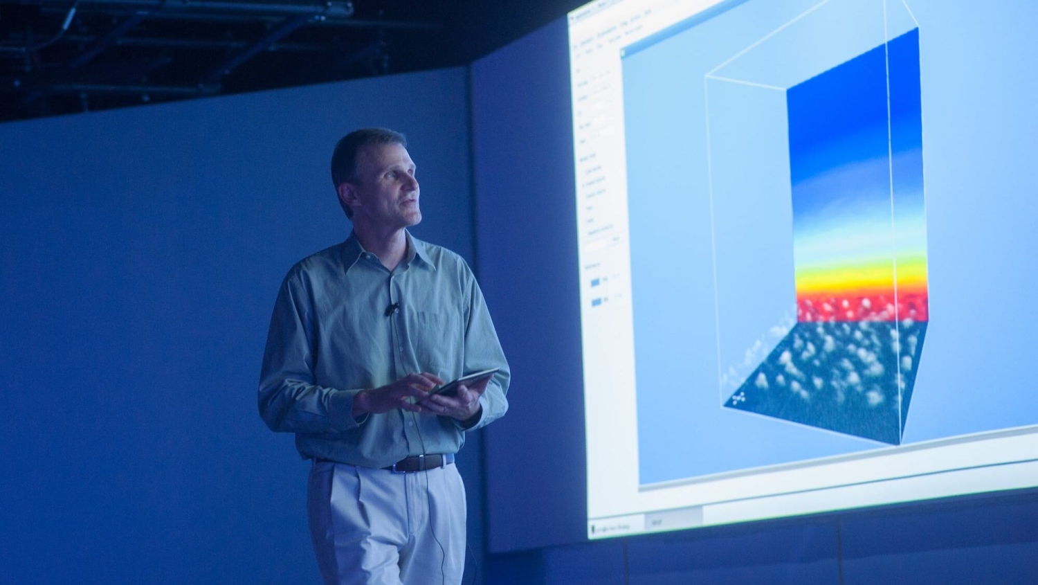 Gary Lackmann standing in front of a large screen