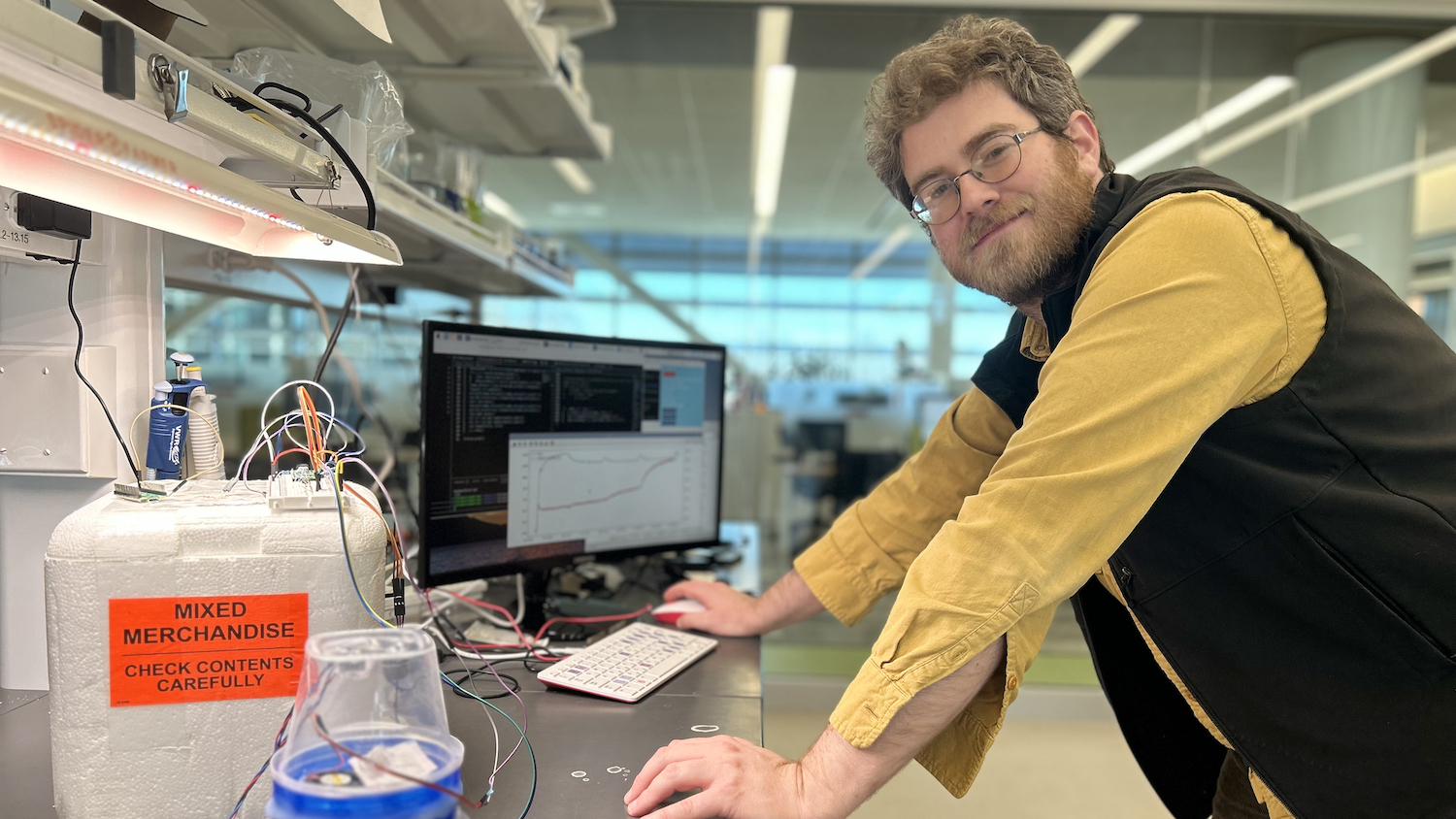 Eli Hornstein in science lab in front of a computer.