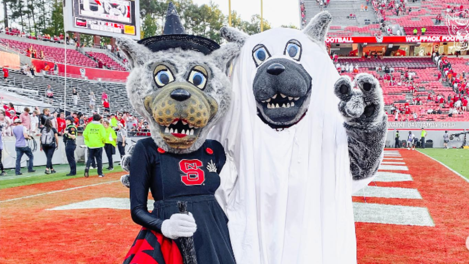 Ms Wuf and Mr Wuf wearing Halloween costumes on field at Carter-Finley Football Stadium